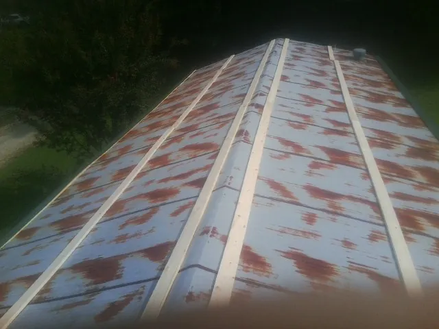 Rusted metal roof panels with new wood purlins before replacement — Storm Damage Roof Repair in Sumiton by Roofing Brothers