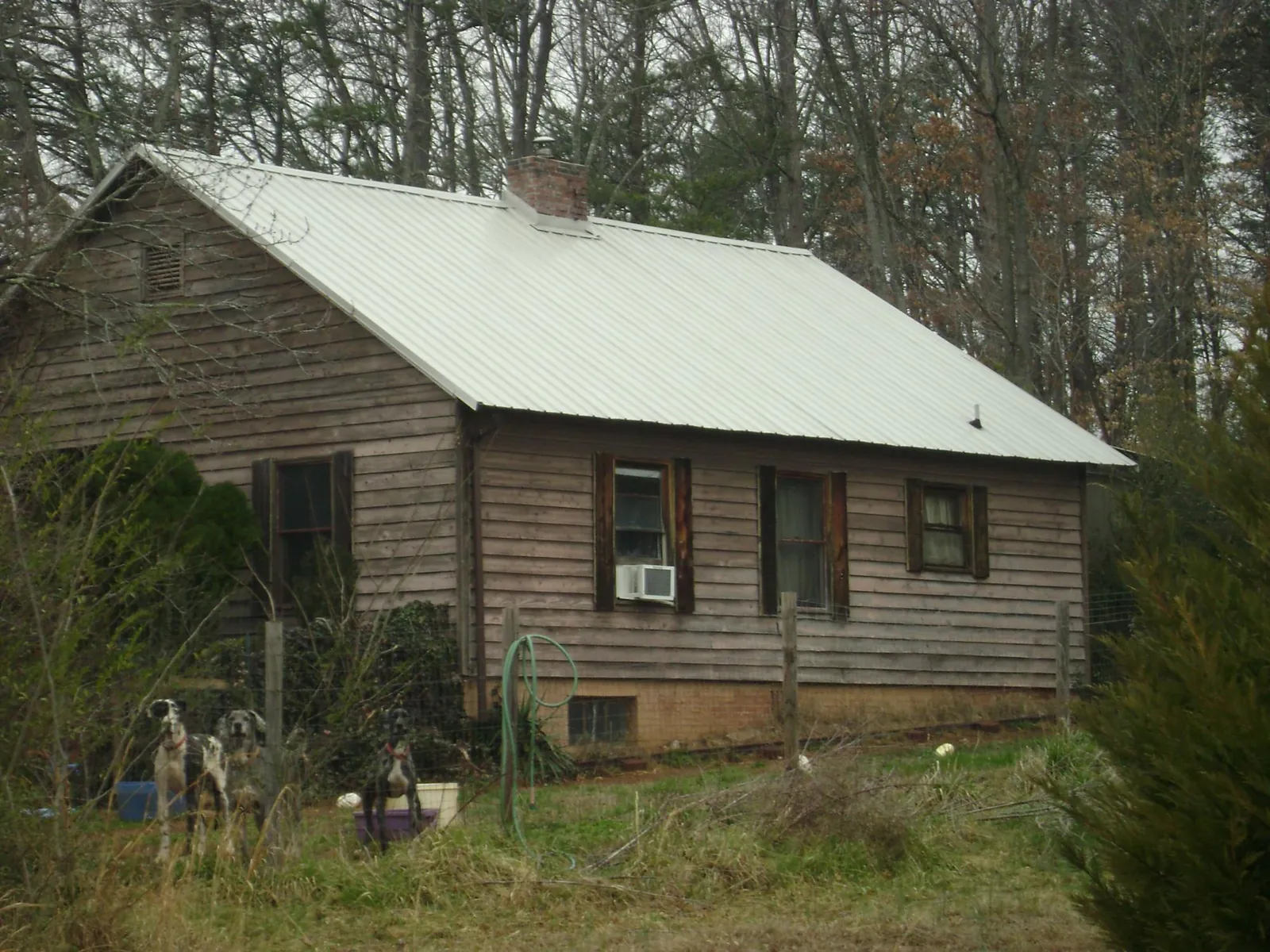 White metal roof on an old wood sided farmhouse, from a Asphalt Shingle Roof Repair job in Sumiton
